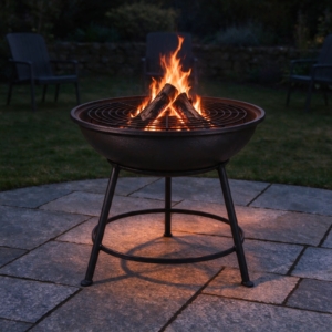 Cast iron fire bowl with a log fire at dusk on an open patio