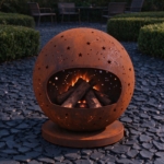 Corten fire globe glowing through its star cut-outs at dusk