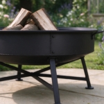 Close-up of the spun steel rim and folding leg of the fire bowl