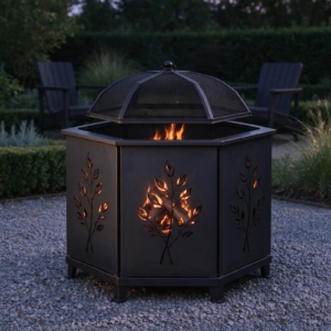 Hexagonal fire pit glowing through its leaf cut-outs at dusk