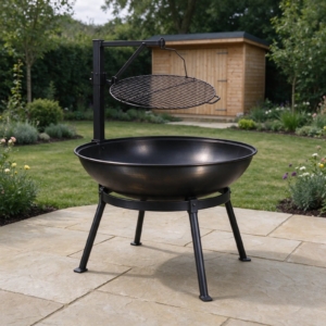 Steel fire pit with swing-arm cooking grill on stone paving in a family garden